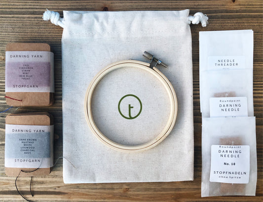 A set of essential darning tools to fix a hole in a sock, a sweater and any woollen garment. A set includes a embroidery hoop, darning needles in 2 different sizes, 100% wool darning yarns in 6 colours and a needle threader.
The set comes in a small cotton draw string bag.