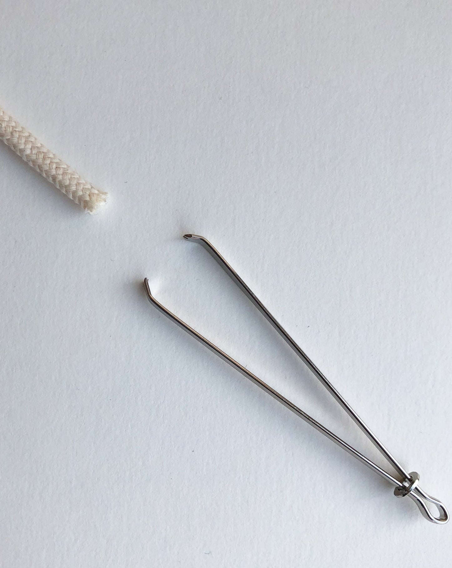 A bodkin will be opened and closed by sliding a little metal ring. Open to insert a string or ruber band, close to secure them in between tweezers, then the bodkin will be threaded the casing.