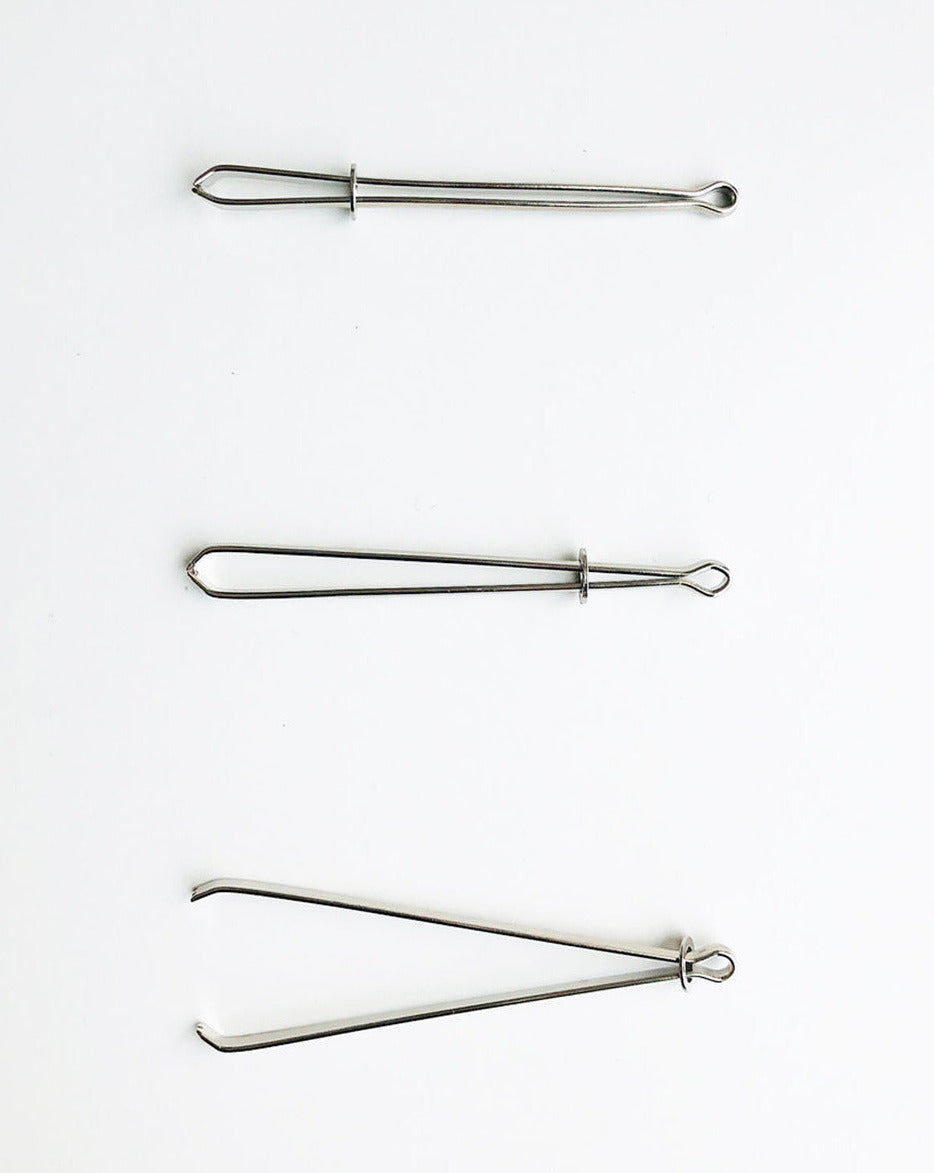 A bodkin will be opened and closed by sliding a little metal ring. Open to insert a string or ruber band, close to secure them in between tweezers, then the bodkin will be threaded the casing.