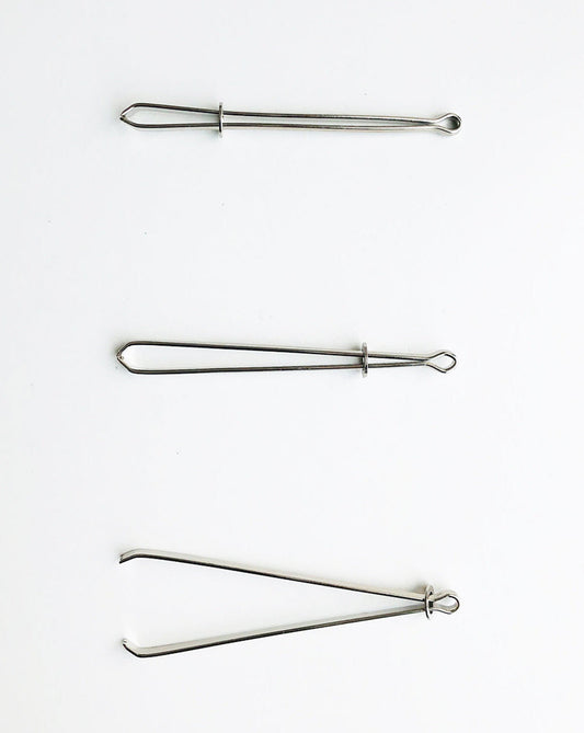 A bodkin will be opened and closed by sliding a little metal ring. Open to insert a string or ruber band, close to secure them in between tweezers, then the bodkin will be threaded the casing.