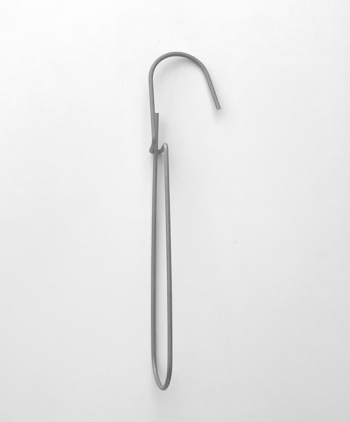 Heavy-duty steel wire hook available in two sizes: large (18 cm long, 12.5 cm loop, 3.5 cm wide) and small (11.5 cm long, 8.5 cm loop, 2 cm wide). Made in Germany, designed for organizing patterns, tools, and scissors. Plastic-free with a spring-clip loop. Matte, powdery finish that becomes smooth over time.
