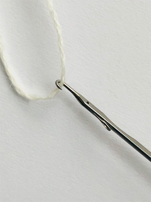 Die Repassiernadel, auch bekannt als Fangnadel, ist ein spezielles Werkzeug zum Stopfen und Ausbessern von Laufmaschen in Strickwaren wie Strumpfhosen, Socken und Pullovern. Ihr feiner, gebogener Haken greift sanft lose oder gerissene Fäden auf und zieht sie wieder an ihren Platz, sodass sich Laufmaschen und Fadenzieher in gestrickten Stoffen leicht reparieren lassen. Ideal für schnelle, unsichtbare Ausbesserungen.