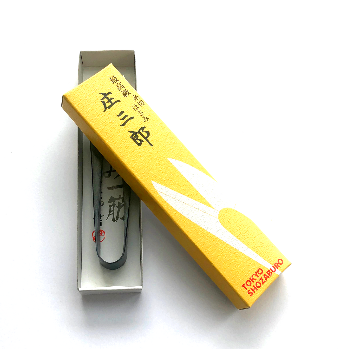 Shozaburo U-shaped thread snips with long 4.5 cm carbon steel blades, designed for precision thread cutting. Compact 10.5 cm size, 30 g weight. Traditional Japanese design in paper wrap packaging, includes English care guide.