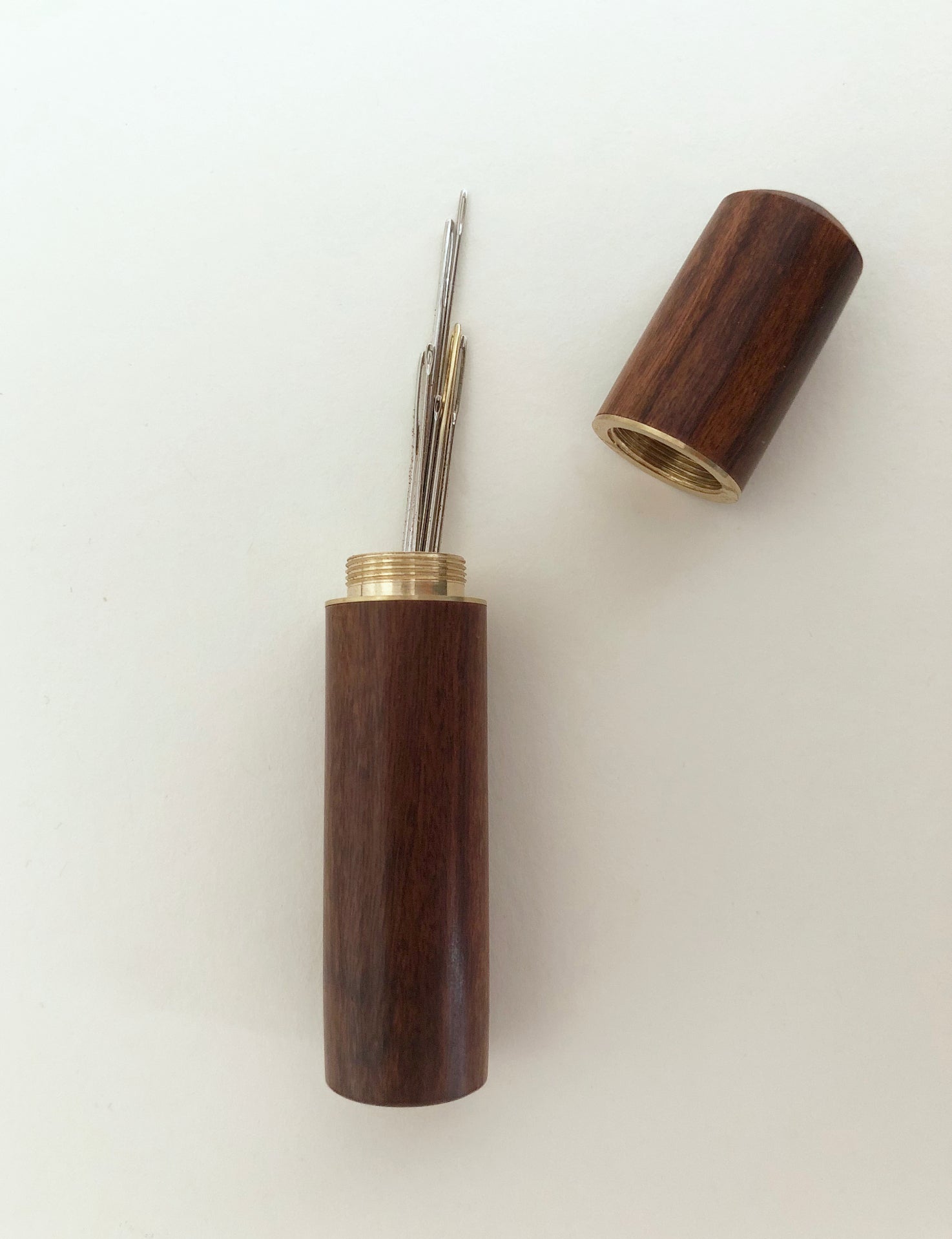 Crafted from natural wood and brass, this needle case is the perfect blend of elegance and practicality for every sewing enthusiast. The secure screw-top lid keeps your needles safely stored, preventing loss and damage. The compact size fits effortlessly into any sewing kit or travel bag, ensuring your needles are always within reach. This needle case is ideal for a variety of needles.