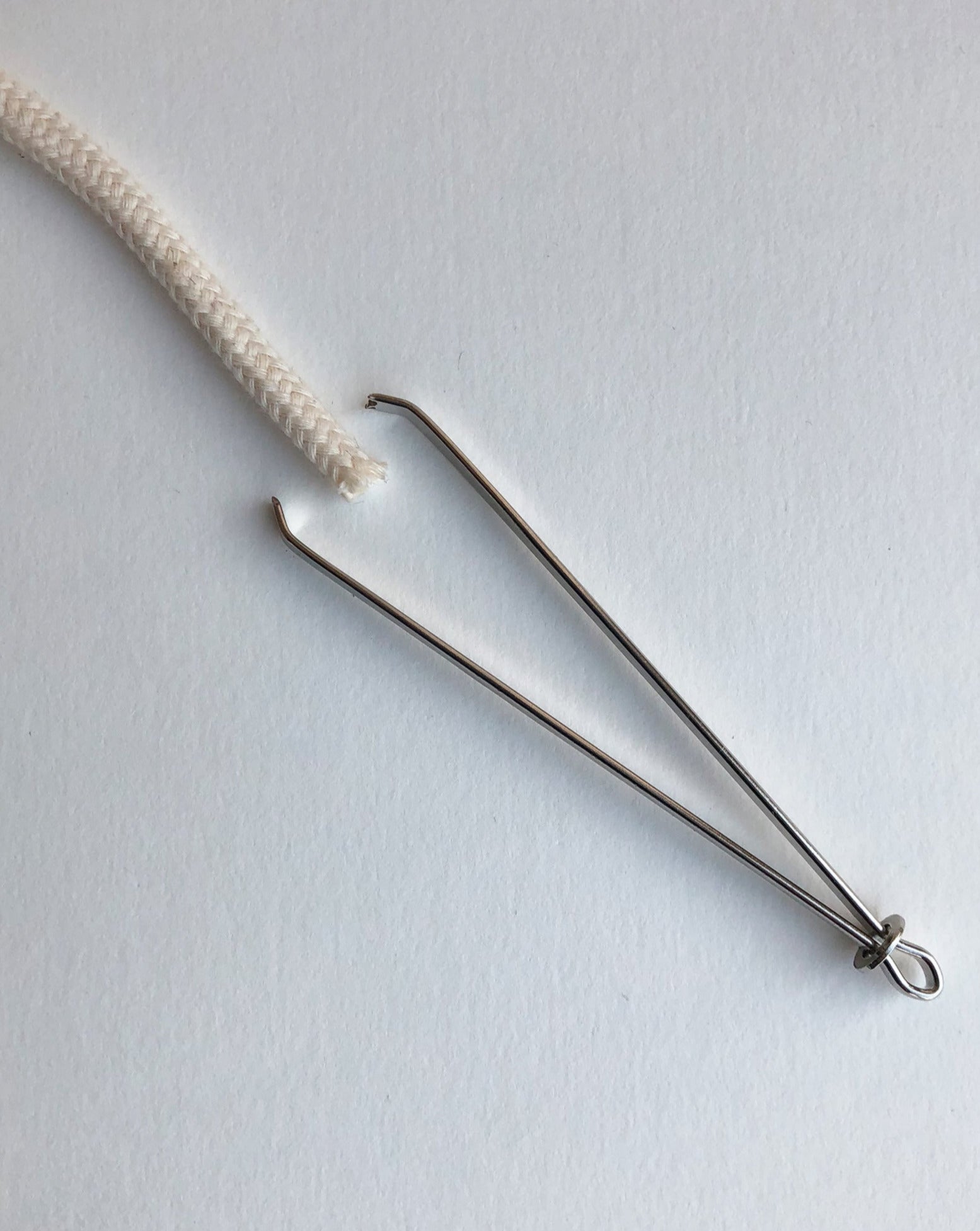 A bodkin will be opened and closed by sliding a little metal ring. Open to insert a string or ruber band, close to secure them in between tweezers, then the bodkin will be threaded the casing.