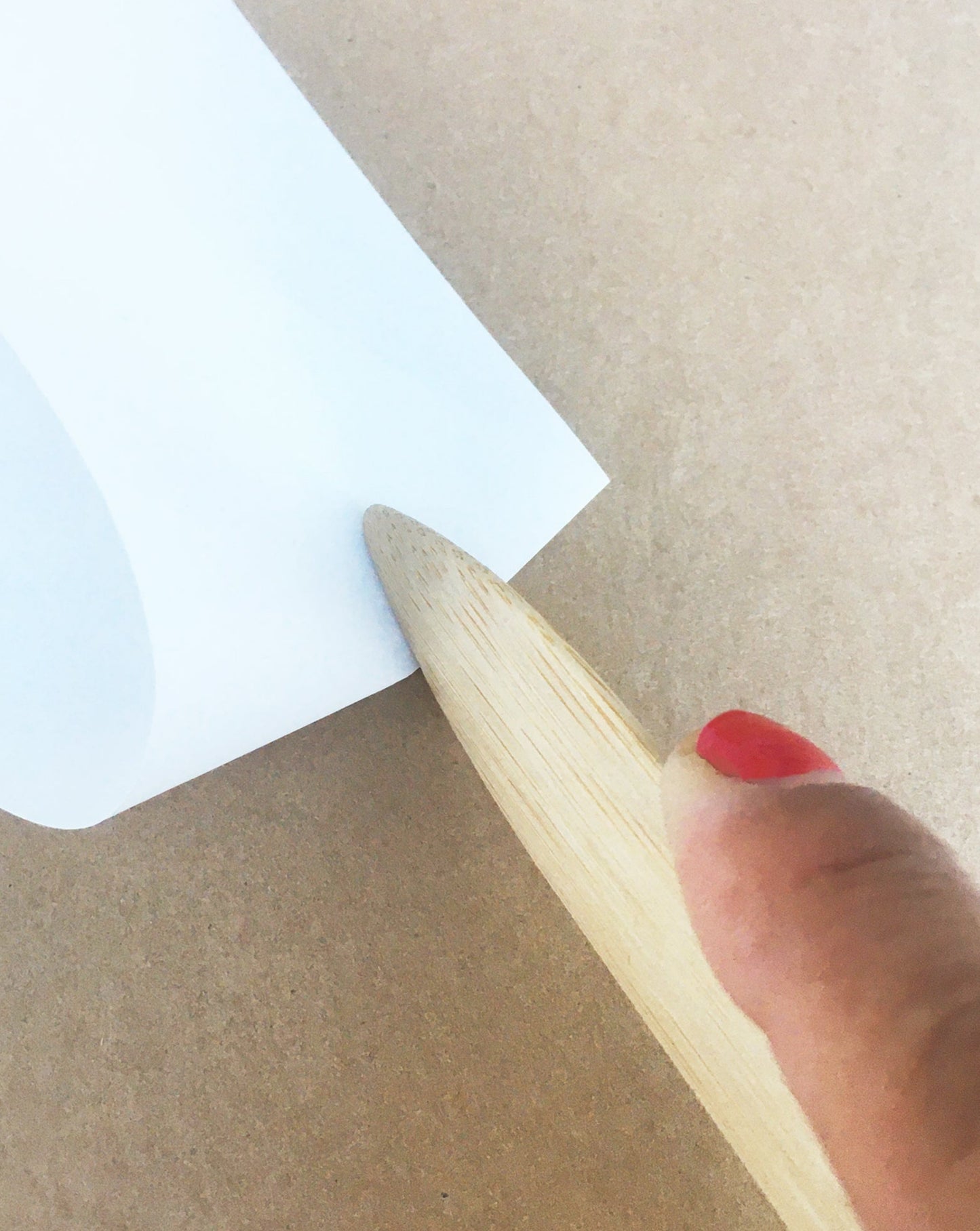 Example image of a seam creaser, folding a piece of paper for the crisp and clean edge